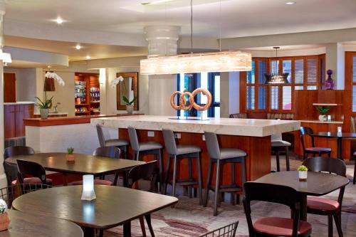 a restaurant with tables and chairs and a bar at Courtyard Rochester Brighton in Rochester