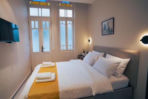 a bedroom with a large bed with two towels on it at Roots Boutique Hotel in Nazareth