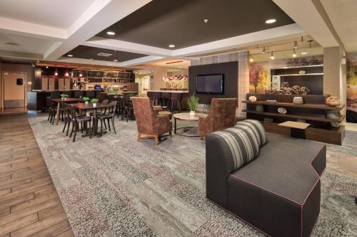a living room with a couch and a dining room at Courtyard by Marriott Rock Hill in Rock Hill