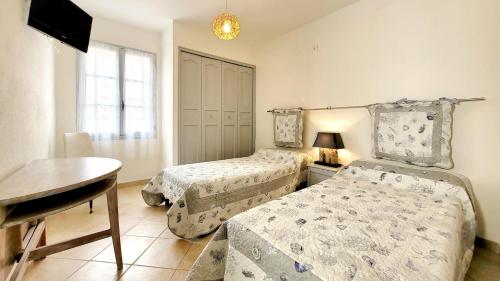 une chambre avec deux lits, une table et un bureau dans l'établissement Studio a 400 m plage et piscine, à Six-Fours-les-Plages