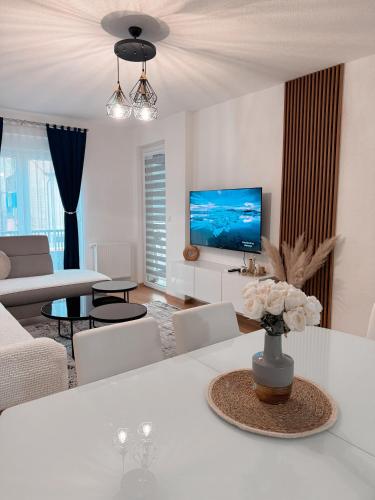 a living room with a white couch and a tv at Apartment Saturday in Travnik
