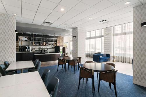 Un comedor con mesas y sillas y una cocina. en Courtyard by Marriott St. Petersburg Downtown, en San Petersburgo