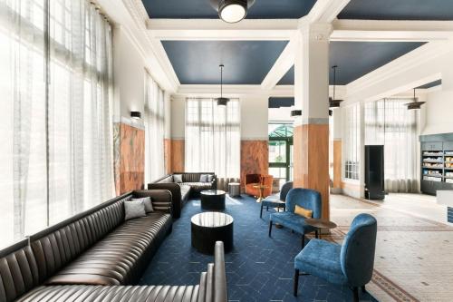 a living room with couches and chairs and windows at Courtyard by Marriott St. Petersburg Downtown in St. Petersburg
