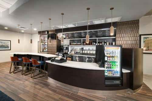 a bar in a restaurant with a counter and stools at Courtyard by Marriott St. Petersburg Downtown in St. Petersburg