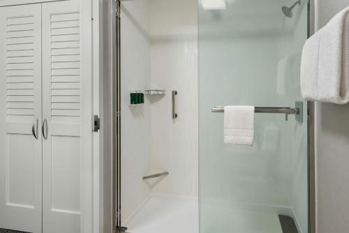 a shower with a glass door in a bathroom at Courtyard by Marriott Silver Spring North/White Oak in Silver Spring