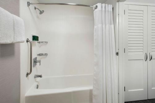 a bathroom with a shower with a white shower curtain at Courtyard by Marriott Silver Spring North/White Oak in Silver Spring