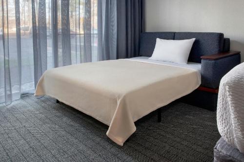 a bed in a room with a large window at Courtyard by Marriott Silver Spring North/White Oak in Silver Spring