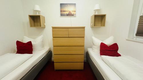 two beds in a room with red pillows on them at Ferienwohnung Felix am See in Joachimsthal
