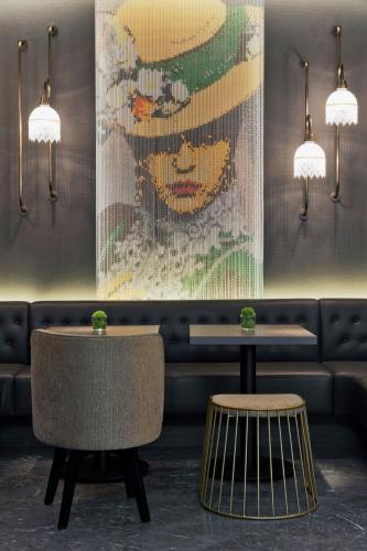 a painting of a woman in a hat on a wall in a restaurant at Renaissance Vienna Schönbrunn Hotel in Vienna