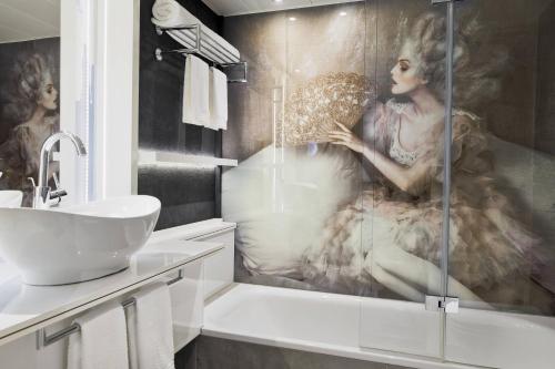 a bathroom with a painting of a woman in a tub at Renaissance Vienna Schönbrunn Hotel in Vienna