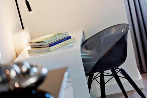 a desk with a stack of books and a chair at Renaissance Vienna Schönbrunn Hotel in Vienna