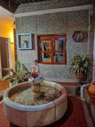a man sitting in a fountain in a living room at Casa avemaría in Cali