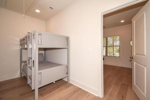 a white bunk bed in a room with a doorway at Tiger's Tail in Auburn in Auburn