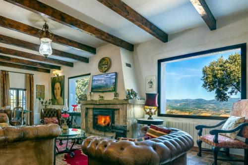 a living room with a fireplace and a large window at Villa San Nicolas - private, tranquil, relaxing.. in Ermita Nueva