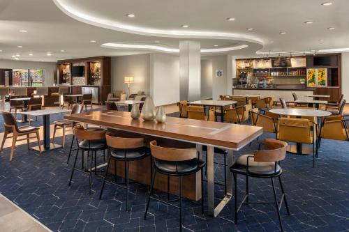 a restaurant with tables and chairs and a bar at Courtyard Minneapolis St. Paul/Roseville in Roseville