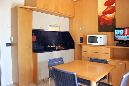 a small kitchen with a table and a microwave at Meubleterme in Grado