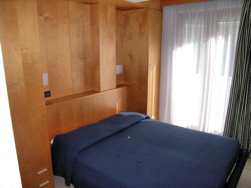 a bedroom with a blue bed and a window at Meubleterme in Grado