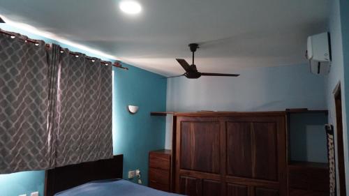 a bedroom with a ceiling fan and a wooden cabinet at Casa QI in Santa Cruz Huatulco