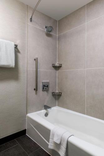 a bathroom with a white tub and a shower at Courtyard by Marriott Phoenix Airport in Phoenix