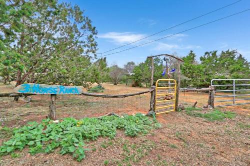 a playground with a swing and a sign that says dances run at Three Horses Ranch in Johnson City