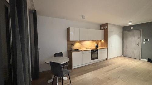 a small kitchen with a table and chairs in a room at Apartament Pogodny in Chojnice