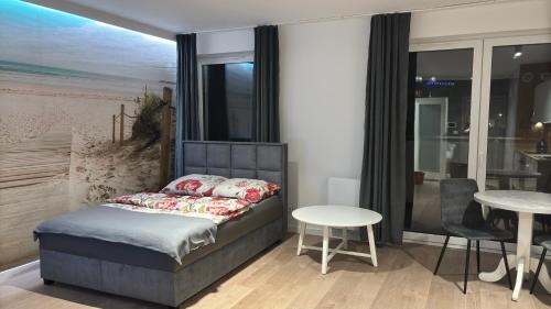 a bedroom with a bed and a table and chairs at Apartament Pogodny in Chojnice