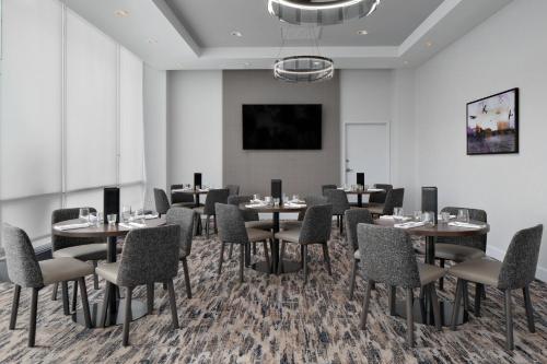 a dining room with tables and chairs and a wall at Courtyard by Marriott Edmonton Downtown in Edmonton