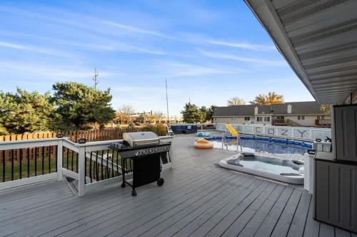 a deck with a grill and a swimming pool at Dreamy Peaceful Retreat - Spa in Ankeny