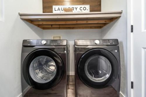 two washing machines in a laundry room with a shelf at Dreamy Peaceful Retreat - Spa in Ankeny
