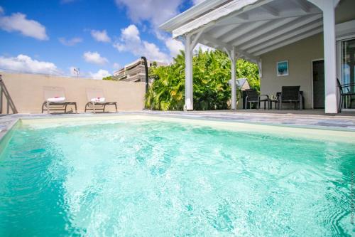 a swimming pool in front of a house at La maison bleue in Fort-de-France