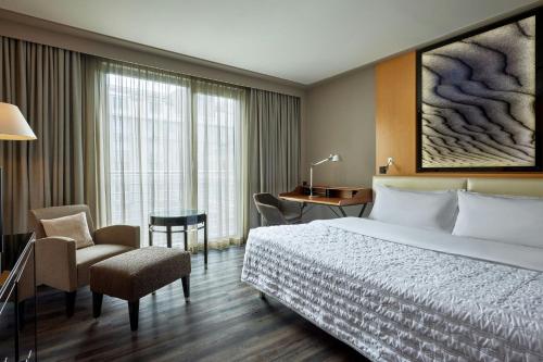 a hotel room with a bed and a desk and chair at Le Meridien Munich in Munich