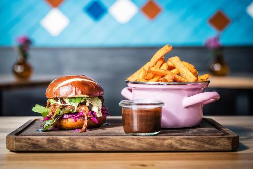 a sandwich and french fries and a cup of sauce at Le Meridien Munich in Munich