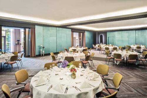 a banquet hall with white tables and chairs at Le Meridien Munich in Munich