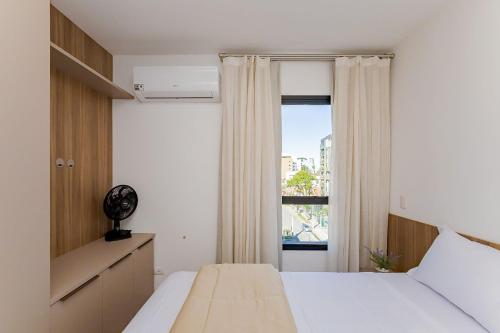 a bedroom with a bed and a window at Condomínio Niagara On The Lake | Gonzaga Stays in Curitiba