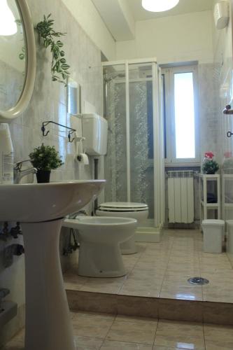 a bathroom with a toilet and a sink and a mirror at Appartamento in Villa Nadin in Monte Compatri