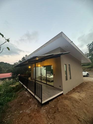 a small house with a porch and a balcony at Villa Colibrí a solo 5mins de Playa Carrillo in Hojancha