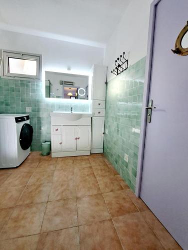 - une cuisine avec du carrelage vert sur les murs et une porte dans l'établissement Cottage 46 m2 - 400m plage et piscine -, à Six-Fours-les-Plages