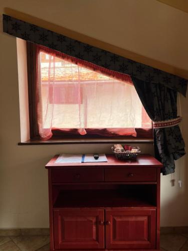 a window in a room with a red dresser in front at BAITA ARIANNA - bilocale MOTTA in Sestriere