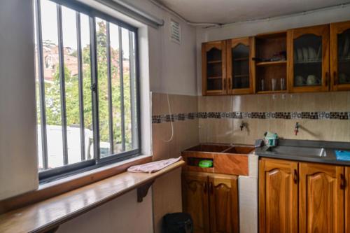 a kitchen with a sink and a large window at Apto Acogedor Cerca Metrocable in Medellín