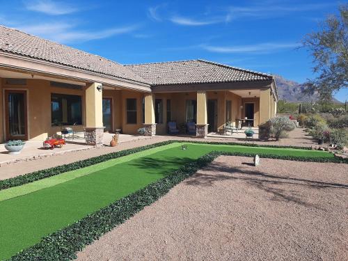 a house with a green lawn in front of a house at AUTHENTIC SANTA FE STYLE VILLA WITH PANORAMIC VIEWS in Gold Canyon