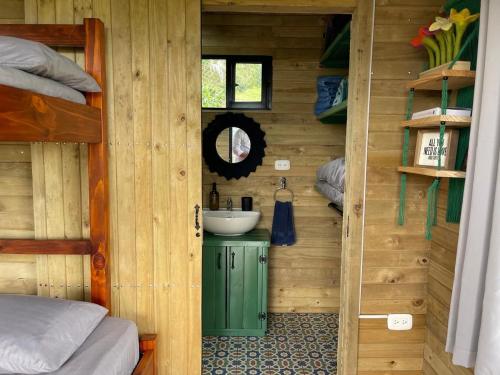 a bathroom with a sink in a wooden cabin at Ecolodge Finca Lalu in Santa Rosa de Cabal