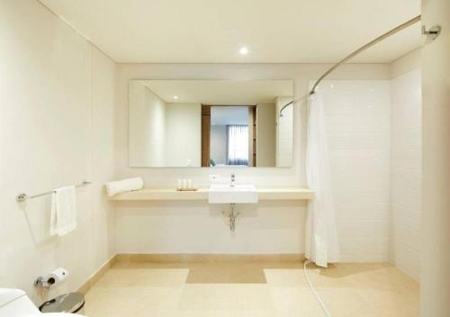 a white bathroom with a sink and a mirror at Caluce Apt 4C by Letoh in Chía