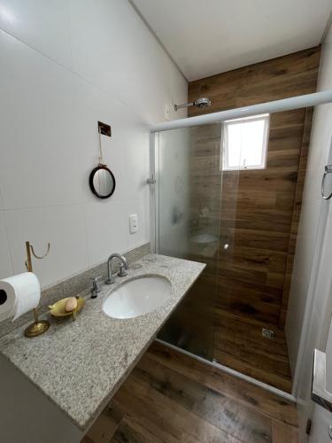 a bathroom with a sink and a shower at Residencial Lunit in Camboriú
