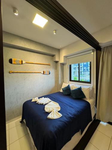 a bedroom with a blue bed with baseball bats on the wall at Makia Beach Experience By All in Porto De Galinhas