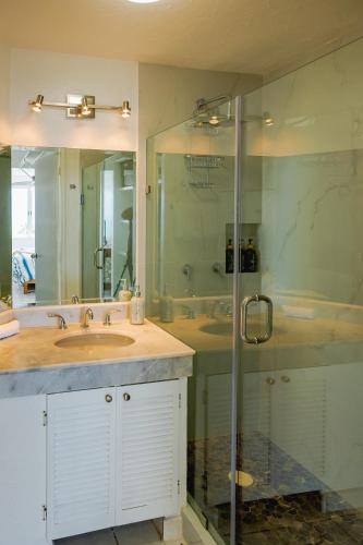 a bathroom with a sink and a glass shower at Casa Lily in Mazatlán