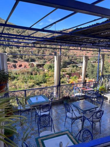 a patio with tables and chairs on a balcony at Kasbah Tifirte Grand Vallet in Ourika