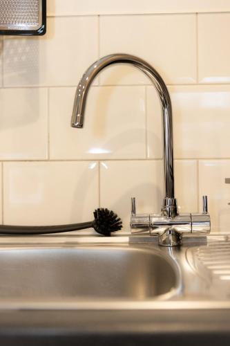 a sink with a faucet in a kitchen at Lethbridge Villa 49 Apartment 2 Super Fibre WiFi, free parking in Southport