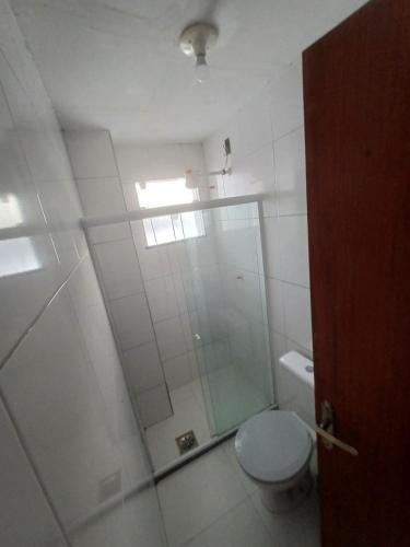 a bathroom with a toilet and a glass shower at Pousada Estrela Mares 101 in Cabo Frio