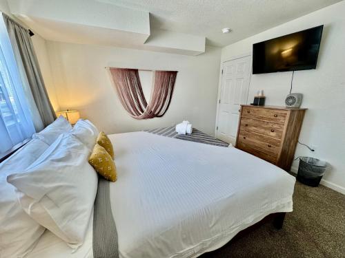 a bedroom with a large white bed and a television at Adventure Lodge in South Lake Tahoe