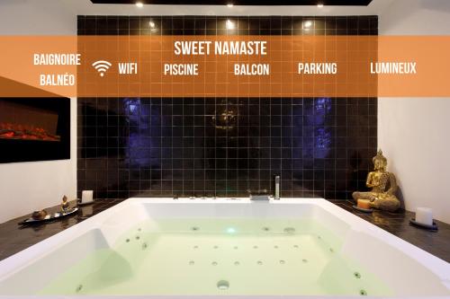 a bath tub in a room with black tiles at Sweet Namaste - Host Provence in Mandelieu-la-Napoule